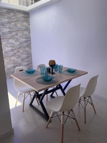 a wooden table with white chairs and a tableablish at Disfruta y descansa en esta casa con Aire acondicionado in Ricaurte