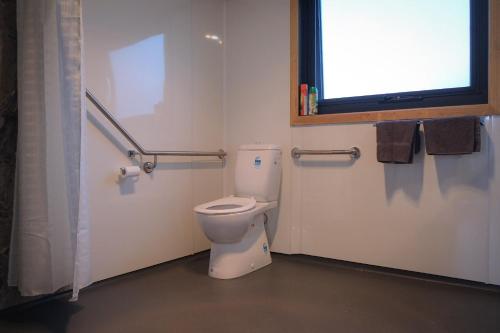 a bathroom with a white toilet and a window at Mount Rumney Escapes Seaview House 2 - Eagle House in Mount Rumney