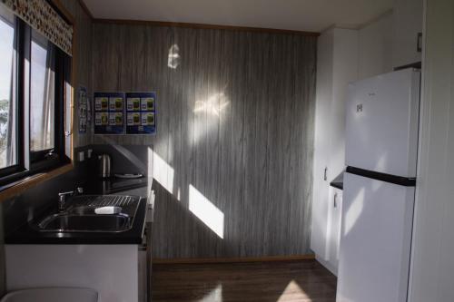 a kitchen with a sink and a refrigerator at Mount Rumney Escapes Seaview House 2 - Eagle House in Mount Rumney