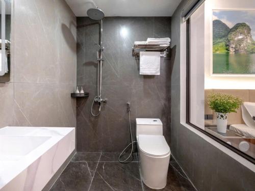 a bathroom with a tub and a toilet and a sink at Si Grand Ninh Binh Hotel in Phúc Trì