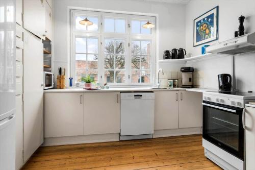 a white kitchen with white cabinets and a window at 20129-samso-Landevejen-32 in Nordby