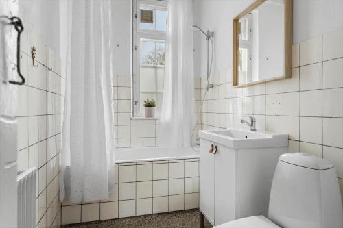 a bathroom with a toilet and a sink and a window at 20129-samso-Landevejen-32 in Nordby