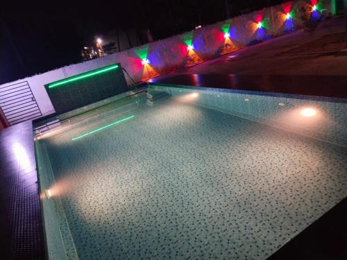 a swimming pool at night with lights on it at SS Grand with swimming pool in Puducherry