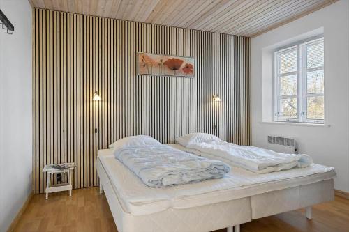 a bed in a room with a striped wall at 20616-Samso-Norreskiftevej-40 in Brundbymark