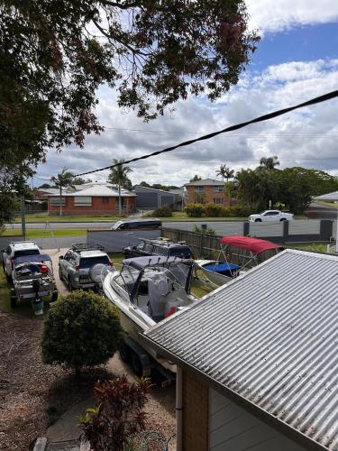 a boat parked in a parking lot next to a house at Welcome to BAY 13 in Tin Can Bay