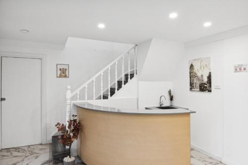 a kitchen with a sink and a staircase at Cozy Double Room in Glenfield - Centrally Located - Shared Bathroom in Glenfield