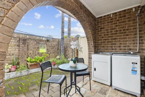 a patio with a table and chairs and a refrigerator at Cozy Double Room in Glenfield - Centrally Located - Shared Bathroom in Glenfield