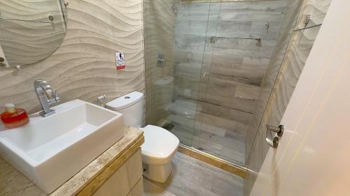 a bathroom with a toilet and a sink and a shower at Apê Cabo Frio - Praia do Forte in Cabo Frio