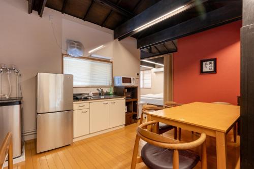 a kitchen with a table and a refrigerator at SHINJUKU Garden-house in Tokyo