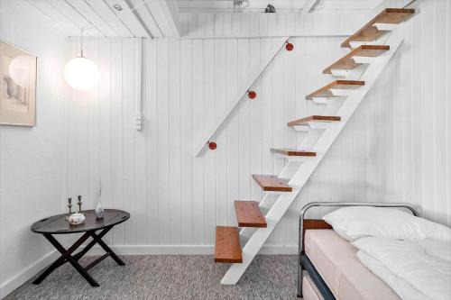 a bedroom with a staircase with a bed and a table at 20203-Samso-Vrangstrup-5 in Tanderup