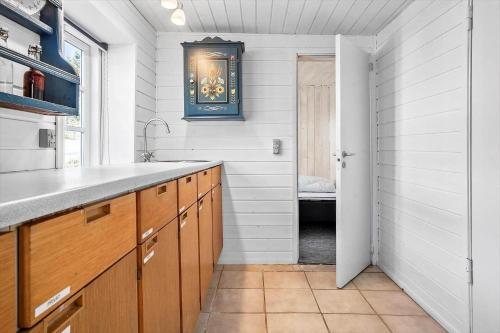 a kitchen with a sink and a door to a bathroom at 20203-Samso-Vrangstrup-5 in Tanderup