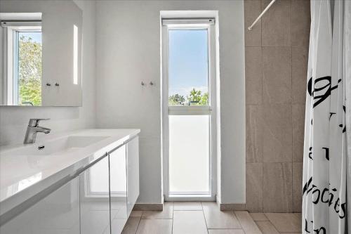 a white bathroom with a sink and a shower at 20503-Samso-Strandkrogen-37 in Sælvig
