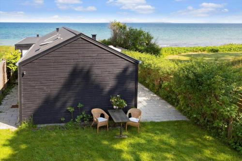 a small shed with two chairs and a table in the grass at 20414-Samso-Strandvejen-63 in Ballen