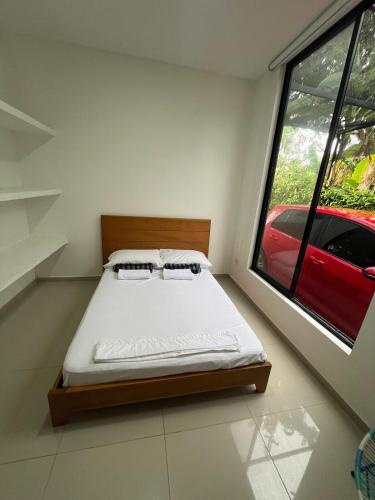 a bedroom with a bed and a red car outside a window at Sunset Private Villa in Ricaurte in Llano del Pozo