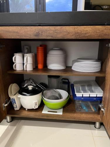 a shelf with plates and bowls and other kitchen utensils at Sunset Private Villa in Ricaurte in Llano del Pozo