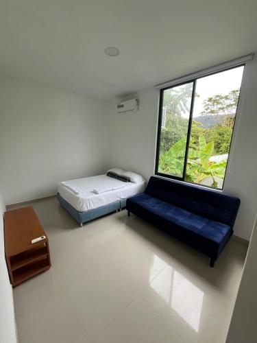a small room with a bed and a window at Sunset Private Villa in Ricaurte in Llano del Pozo