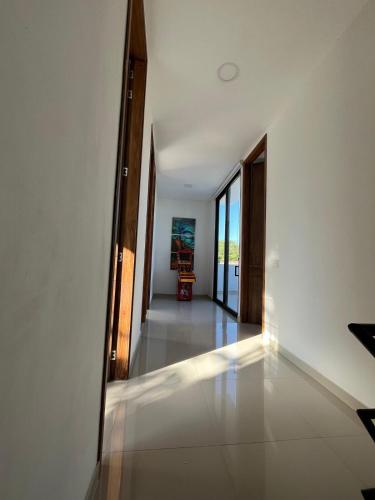 a hallway of a house with white walls and windows at Sunset Private Villa in Ricaurte in Llano del Pozo