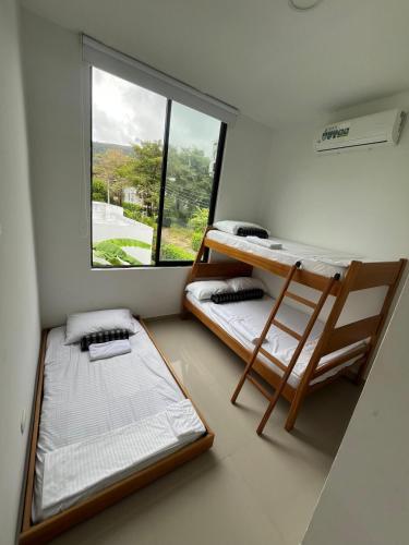 a room with two bunk beds and a window at Sunset Private Villa in Ricaurte in Llano del Pozo