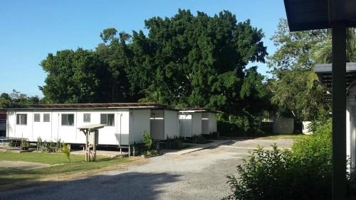 a small white building with trees in the background at Bushchooks Travellers Village in Bororen