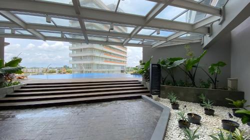 a lobby with stairs and a building in the background at REOTEL at THE NOVE - NUVASA BAY serviced Apartment in Pulau Nongsa