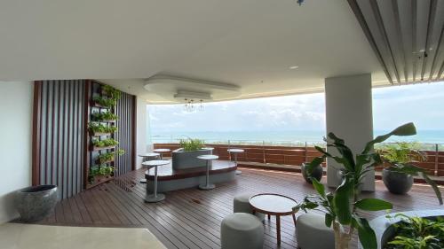 a room with a balcony with a view of the ocean at REOTEL at THE NOVE - NUVASA BAY serviced Apartment in Pulau Nongsa