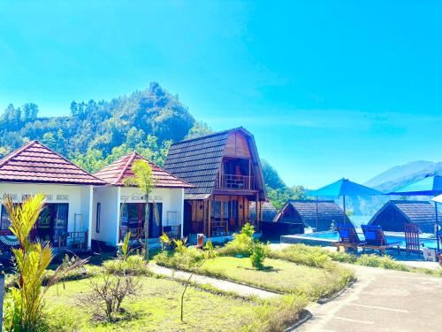 a group of houses with mountains in the background at Bali Cottages Lake View in Kintamani