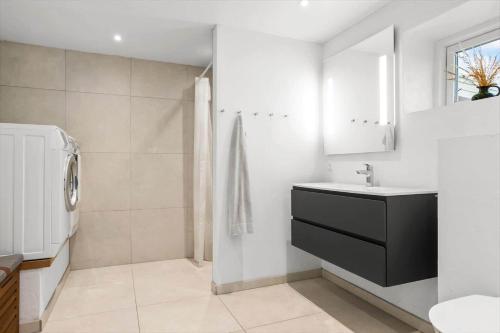 a bathroom with a sink and a toilet and a mirror at 20417-Samso-Ballenvej-26 in Ballen