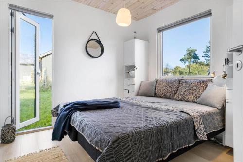 een slaapkamer met een bed en grote ramen bij 20142-Samso-Laerkevej-9-C in Nordby