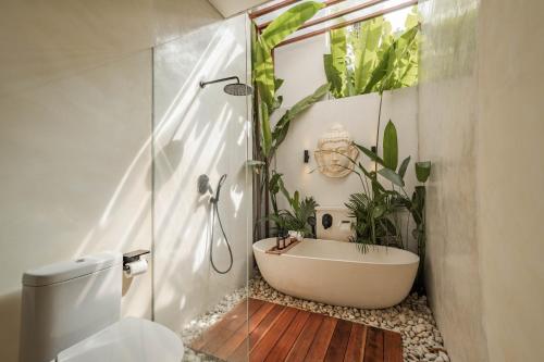 a bathroom with a white bath tub and plants at Lucky Villa 1 in Uluwatu