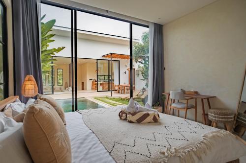 a bedroom with a bed and a large window at Lucky Villa 1 in Uluwatu