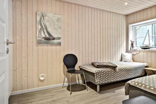 a room with a bed and a chair in it at 20123-Samso-Maarup-Havn-7-A in Nordby