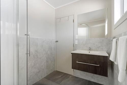 a white bathroom with a sink and a shower at Comfort Inn Sunset Thames in Thames