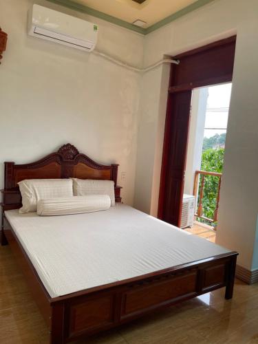 a bedroom with a large bed in a room with a window at Duy Anh Hotel Biên Hoà in Bien Hoa