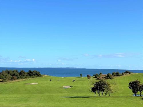 a view of a golf course with the ocean in the background at 20328-Samso-Besservej-35 in Tranebjerg