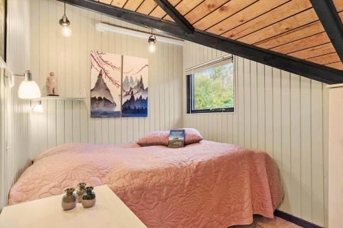 a bedroom with a pink bed and a window at 20114-Samso-Blamejsevej-9 in Nordby
