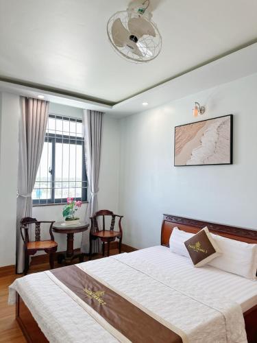 a bedroom with a bed and a table with chairs at Thiên Trang 2 Hotel - Khách sạn gần bến tàu Rạch Giá in Rach Gia