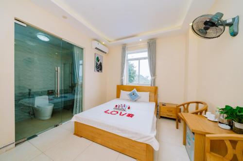 a bedroom with a bed and a shower and a desk at Cat Ba Lang Chai Hotel in Cat Ba