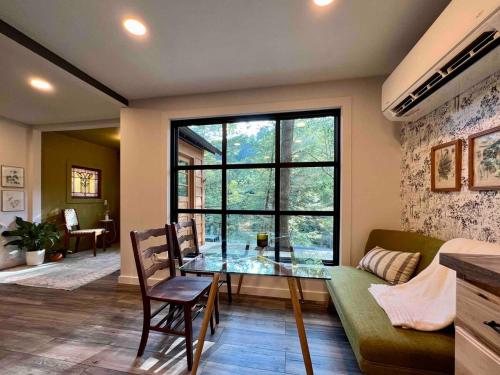a living room with a glass table and a large window at Gwen's Cottage at Water's Edge in Portersville
