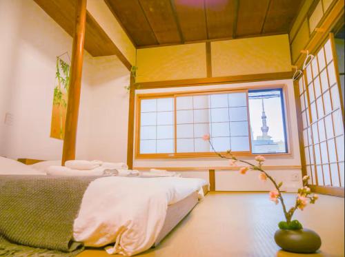 a bedroom with two beds and a window at 9Stay西浅草 in Tokyo