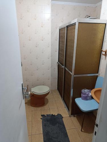 ein Badezimmer mit Toilette und Waschbecken in der Unterkunft Caiçara de frente para mar in Praia Grande