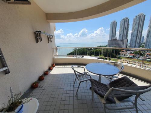 a balcony with a table and chairs and a view of the ocean at Rainbow paradise at Tanjung Bungah in Tanjung Bungah