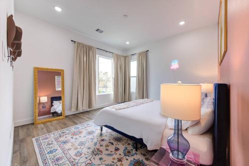a bedroom with a bed and a mirror and a lamp at HoustonHideaway 3BR/3.5BA near UH BBQ & Pool Table in Houston