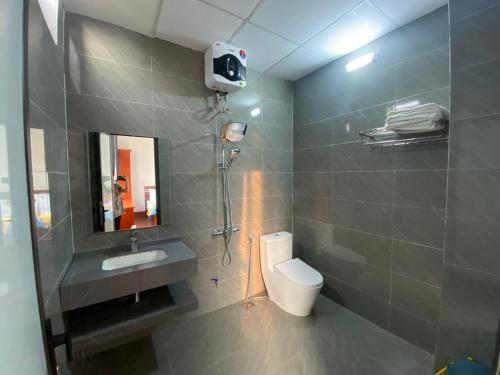 a bathroom with a toilet and a sink and a mirror at Cô Tô Lương Chi in Quang Ninh