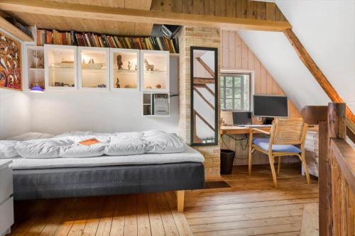a bedroom with a bed and a desk with a computer at 20141-Samso-Ballebjergvejen-9 in Nordby