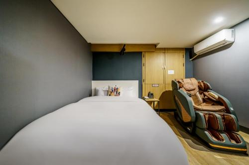 a bedroom with a bed and two chairs in it at Bulgwang 3S Hotel in Seoul