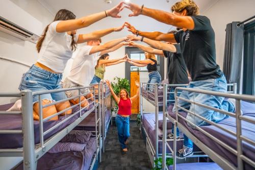 a group of people standing on bunk beds in a room at Mad Monkey Kings Cross in Sydney