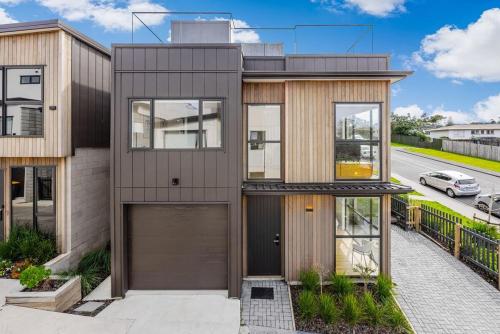 an image of a house with a garage at Holiday Escape Modern 4BR Home by Waiake Beach in Auckland