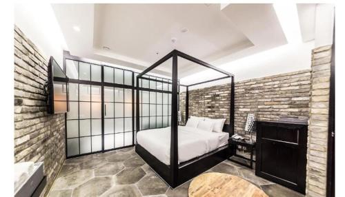 a bedroom with a canopy bed in a brick wall at Hotel Forestar in Seoul