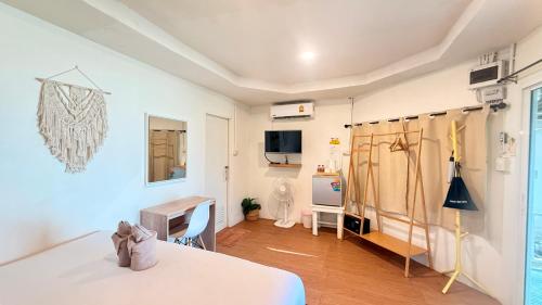 a bedroom with a bed and a desk and a table at Apache Loongdum Koh Samed in Ko Samed