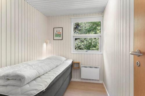 a bed in a room with a window at TV1225-Bindslev-Margueritevej-4 in Bindslev